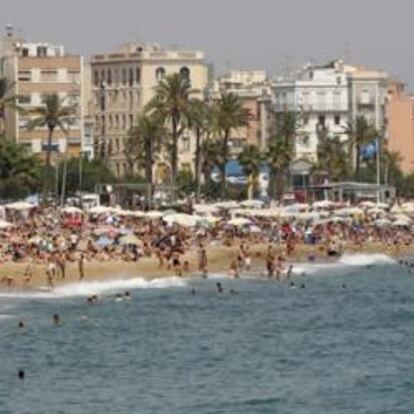 Imagen de una playa de Barcelona plagada de turistas