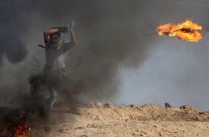 Un manifestante palestino lanza un neumático en llamas durante un enfrentamiento con las tropas israelíes, cerca de la frontera con Israel al sur de la Franja de Gaza.