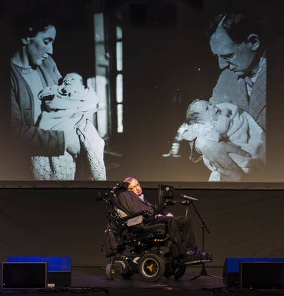 Stephen Hawking, diante de duas fotos com sua mãe e seu pai.