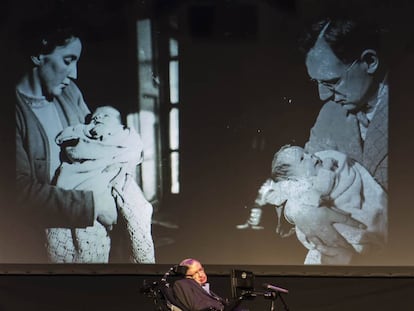 Stephen Hawking, diante de duas fotos com sua mãe e seu pai.