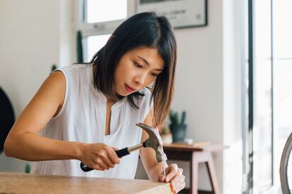 Focused Young Woman Assembling Furniture At Home