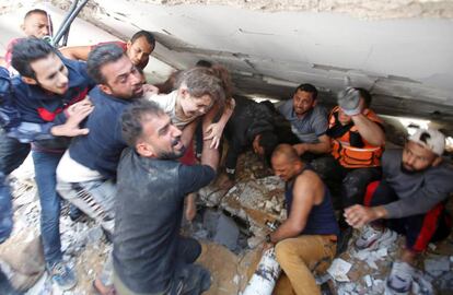 Palestinos rescatan a una niña entre los escombros de un edificio en Gaza, este domingo. El Ejército israelí ha incrementado los bombardeos sobre la franja de Gaza, con más de un millar de operaciones aéreas, mientras las milicias de Hamás han redoblado el disparo de cohetes tras cerca de tres millares de lanzamientos. Desde la guerra de 2014, que se prolongó durante dos meses, ambas partes no se habían enfrentado con tanta intensidad.