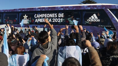 Los aficionados de Argentina celebran a los futbolistas de la selección subidos en el camión, este domingo.