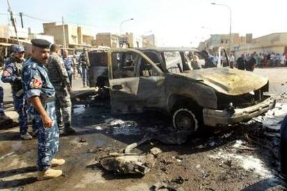 Policías iraquíes inspeccionan los daños causados tras un atentado en Irak.