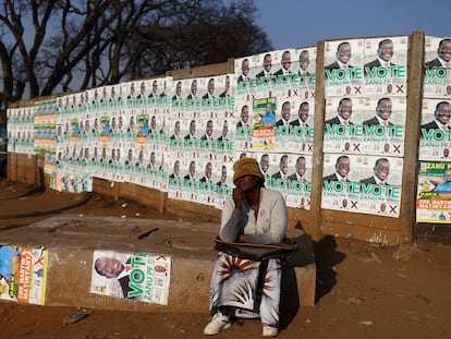 Una mujer posa junto a las imágenes de candidatos en el barrio de Mbare, en Harare, el 21 de agosto.