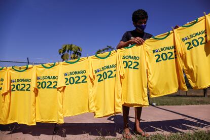 Un chaval en Brasilia este sábado con camisetas que imitan a las de la selección y piden la reelección de Bolsonaro el año que viene.