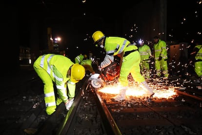 La rede de cercanías de Madrid consta de 360 kilómetros de vía. En esta imagen varios operarios cortan con una radial una sección de una vía.