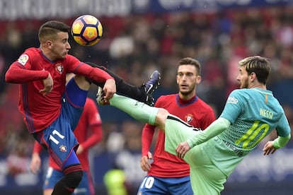 Alex Berenguer controla la pelota con la cabeza ante el defensa del Barcelona, Lionel Messi.