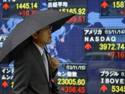 Un peatón pasa por delante de una pantalla con los resultados de la Bolsa de Tokio.EFE/Archivo