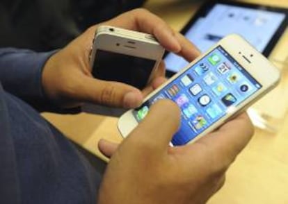 Una persona observa un iPhone 5, la nueva apuesta de Apple en el mundo de la telefonía móvil.