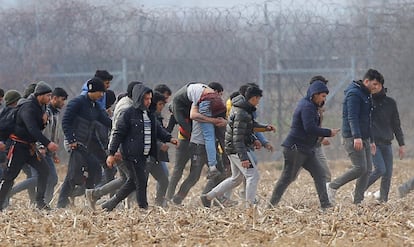 Varios migrantes llevan a un hombre herido cerca del paso fronterizo de Pazarkule en Turquía.