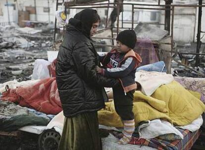 Una mujer y su hijo, tras la destrucción de su campamento en Año Nuevo en Milán.