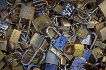 El peso de los "candados del amor" que invaden el Pont des Arts de París hace temer al ayuntamiento parisino por la estabilidad de las barandillas del puente. EFE/Archivo