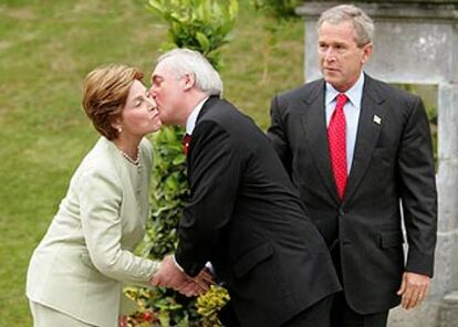 El primer ministro irlandés, Bertie Ahern, besa a la esposa del presidente George W. Bush, ayer en Dromoland Castle