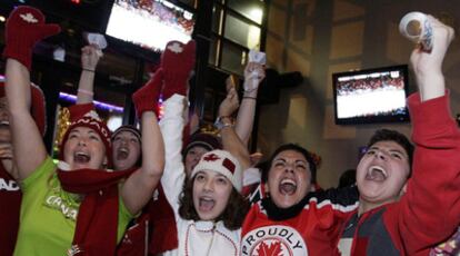 Aficionados canadienses celebran la victoria de Canadá en hockey.