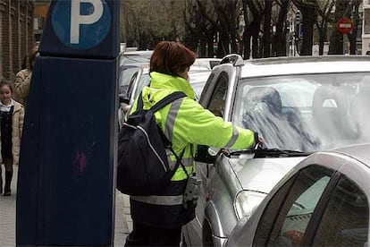 Una controladora coloca una denuncia en un turismo en la calle de Juan Bravo, en diciembre pasado.