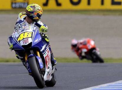 Valentino Rossi mira atrás, a Casey Stoner, durante la carrera de ayer en Motegi.