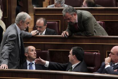 El portavoz del PNV, Josu Erkoreka (sentado, a la izquierda), habla con otros diputados de su grupo.