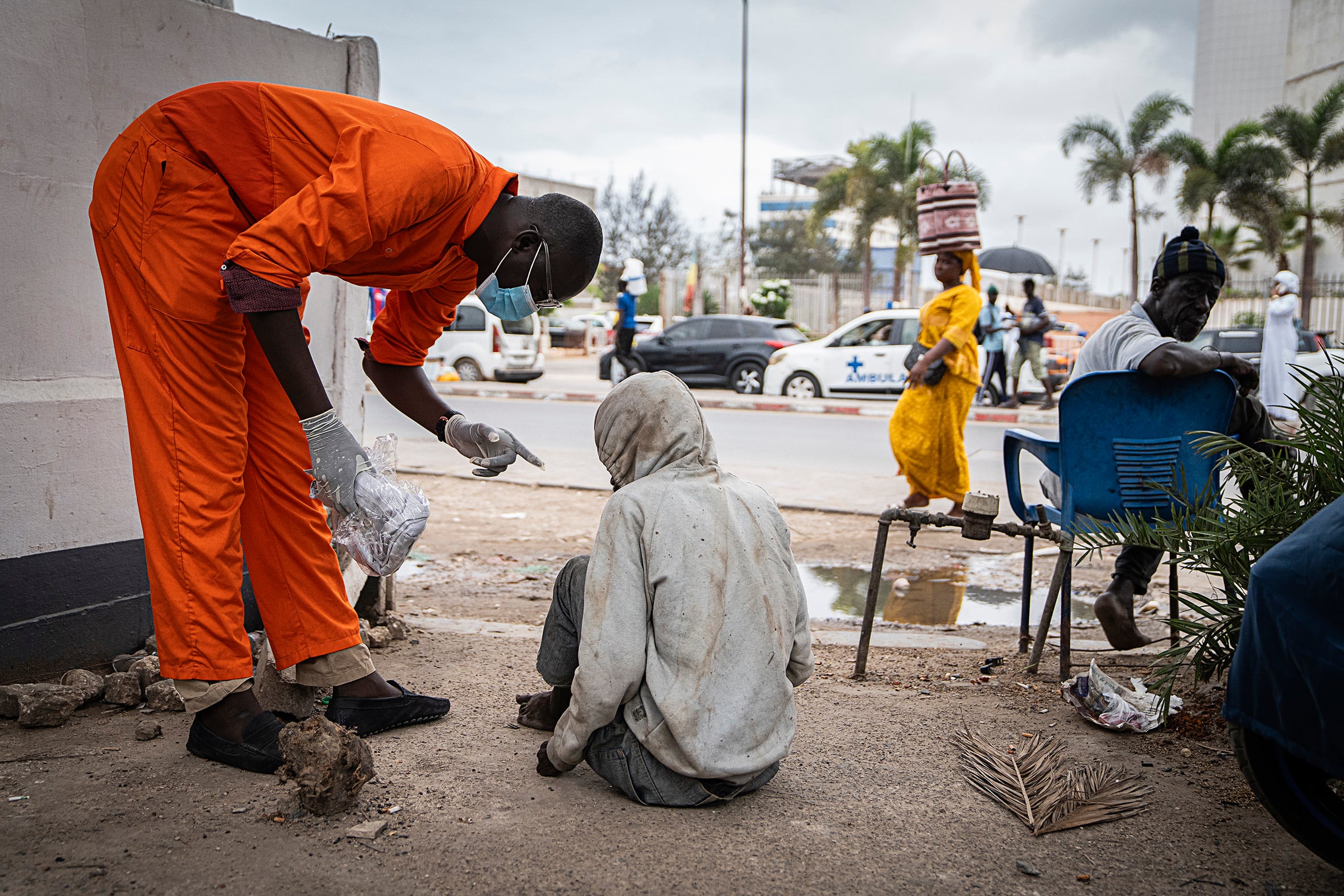 Ibrahima Seck, arquitecto de profesión y creador de 'Help and Clean Mind' atiende a Mamadou Diallo, quien vive en las calles de Dakar, el 12 de julio.