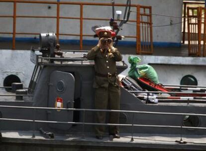 Un soldado de Corea del Norte vigila el paso de un barco chino por el río Yalu, fronterizo entre Corea del Norte y China, cerca de Dandong, provincia de Liaoning ( China).