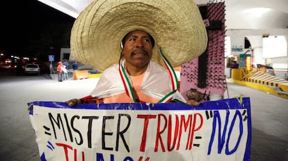 Martin Macias segura cartaz contra Trump em Ciudad Juarez, no M&eacute;xico.