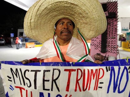 Martin Macias segura cartaz contra Trump em Ciudad Juarez, no M&eacute;xico.