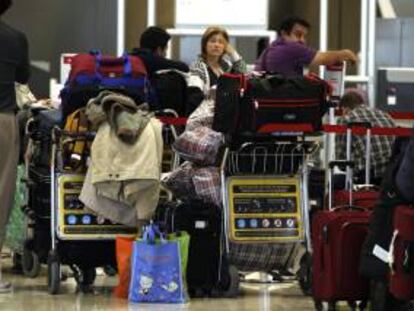Numerosos pasajeros esperan en los mostradores de Iberia en el aeropuerto de Barajas. EFE/Archivo