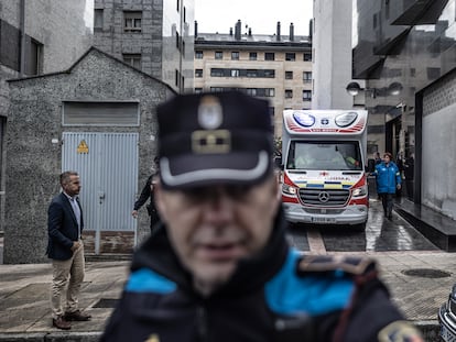 Policía local y servicios de emergencia, en la puerta del portal donde residían las menores que han fallecido en el barrio de La Ería, Oviedo (Asturias).
