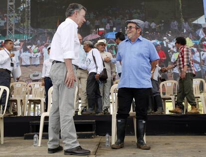 El presidente colombiano Juan Manuel Santos (i) habla con Timochenko (d), el principal comandante de las Fuerzas Armadas Revolucionarias de Colombia (FARC), durante el acto para conmemorar la finalización del proceso de desarme en Buenavista.
