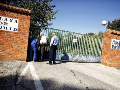 Un operario de Patrimonio Nacional coloca candados a la entrada del club La Playa de Madrid.