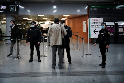 National Police officers checking passenger ID at Atocha railway station in Madrid.