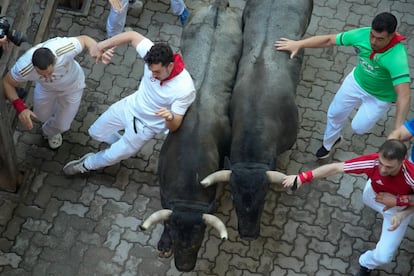 Un corredor se resbala durante el sexto encierro de los sanfermines celebrado este sábado.