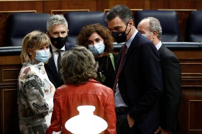 El presidente del Gobierno, Pedro Sánchez (a la derecha), conversa con las diputadas socialista, María Luisa Carcedo (de espaldas) y Susana Ros (a la izquierda) junto al ministro del Interior, Fernando Grande-Marlaska (segundo por la izquierda), la ministra de Hacienda María Jesús Montero (en en centro) y el ministro de Justicia, Juan Carlos Campo (a la derecha) tras la intervención del líder de Vox.