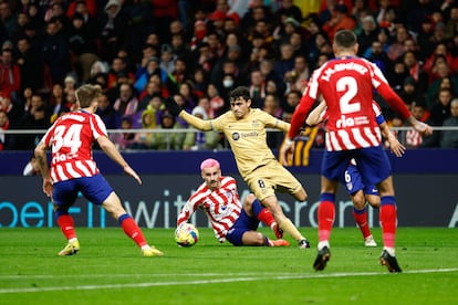 Pedri se lleva el balón ante Griezmann durante el partido entre el Atlético y el Barcelona este domingo.