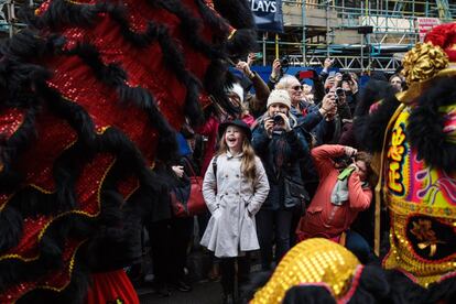 Un grupo de asistentes de la fiesta del Año Nuevo Chino miran la danza del león durante el desfile en Londres (Inglaterra).