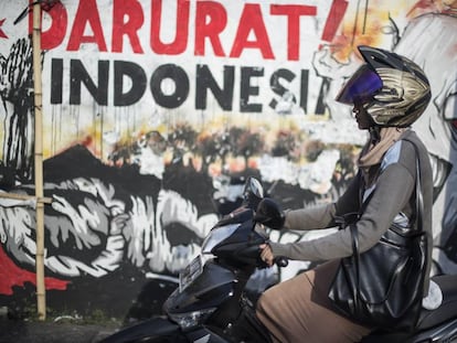 Una motorista delante de uno de los murales de X-Go, en Surabaya.