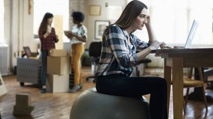 A woman seated on a fitball, which is recommended by physiotherapists.