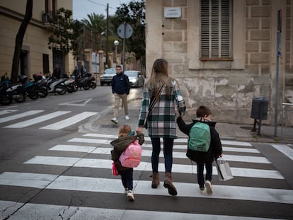 Una mujer acompaña a dos niños al colegio en Cataluña.