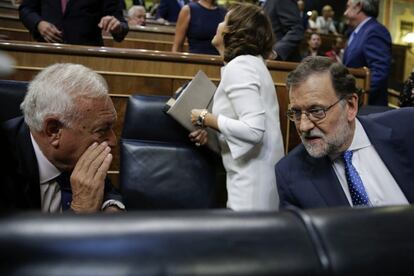 El presidente del Gobierno en funciones, Mariano Rajoy, conversa con el ministro de Asuntos Exteriores, José Manuel García-Margallo, antes de pronunciar su discurso de investidura.