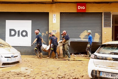 Los bomberos trasladan un cadáver en Catarroja este viernes.