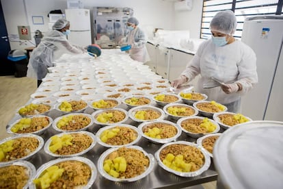 Empleadas del proyecto Mãos de Maria (Manos de María) preparan los platos de arroz, alubias y carne que reparten a diario.