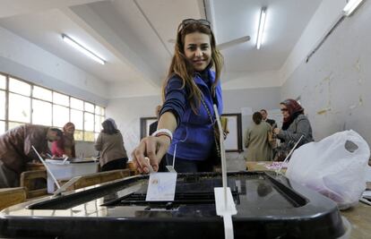 Una mujer egipcia deposita su voto en una urna durante las elecciones por la nueva Constitución en Egipto.