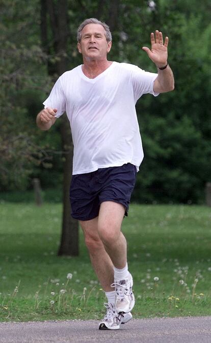 El entonces presidente de Estados Unidos George W. Bush , saluda mientras corre haciendo <i>footing</i> en Des Moines, Iowa, en 2001