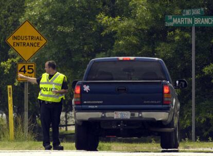 Un policía le indica a un conductor que la carretera está cerrada debido a la explosión en la planta empacadora de carne en Garner, Carolina del Norte.