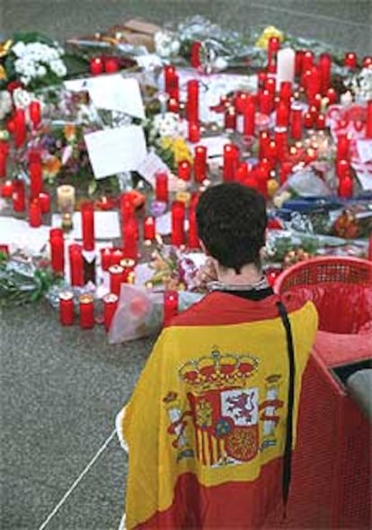 Un joven contempla las velas colocadas en la estación de Atocha en memoria de las víctimas.