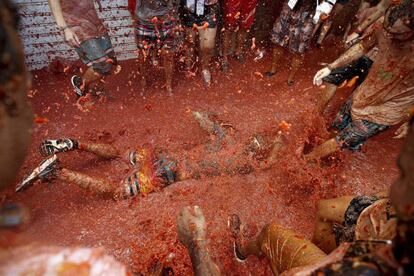 Participante en la fiesta La Tomatina en 2016, tendido en el suelo.