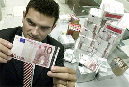 Un empleado de un banco francés analiza un billete de 10 euros.