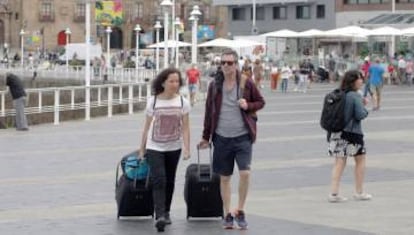 Turistas cruzan una avenida de Gijón, en una fotografía de archivo.