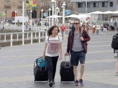 Turistas cruzan una avenida de Gijón, en una fotografía de archivo.