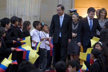 El secretario general de la ONU, Ban Ki-moon, y el presidente colombiano, Juan Manuel Santos, junto a niños que portan la bandera colombiana en el palacio presidencial de Bogotá.